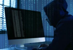 Mann im Kapuzenpullover, der vor einem Bildschirm sitzt und programmiert